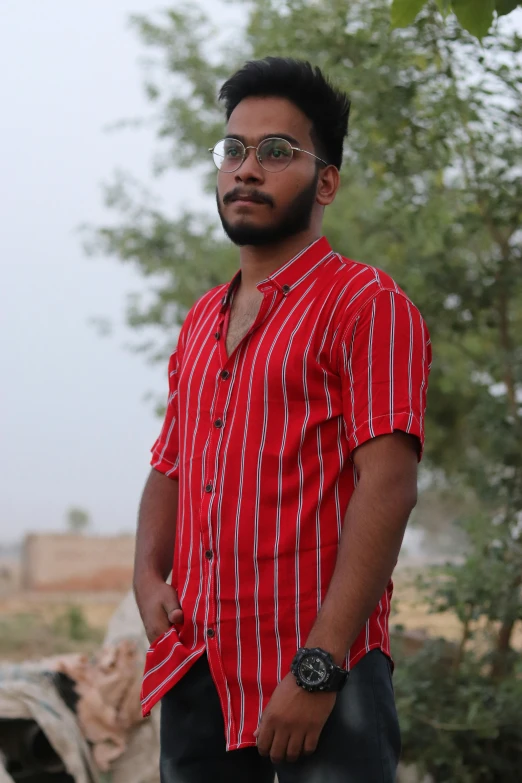 man with red and white striped shirt on posing