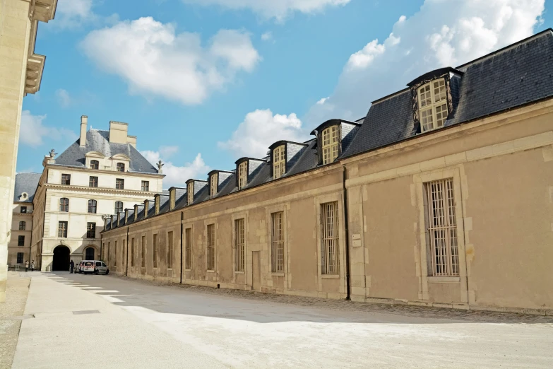 a stone building with many windows has a street between it