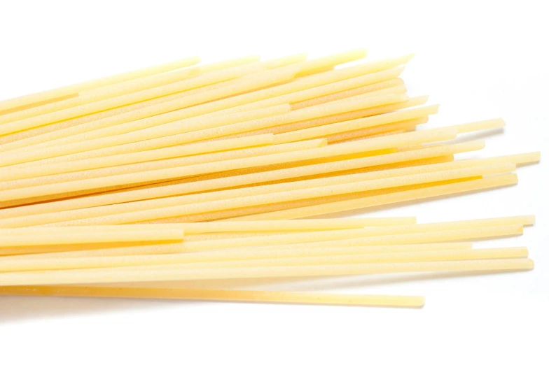 several straws of yellow colored material on a white background