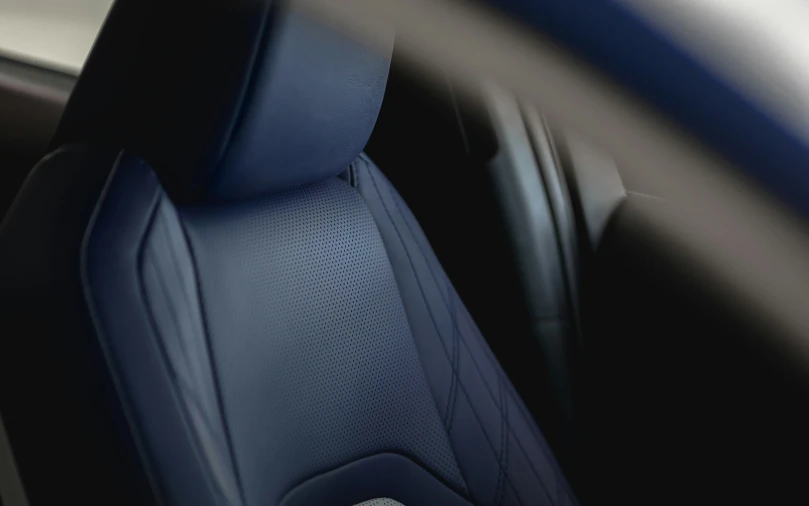 the interior of a car, which has a white seat belt and blue trim