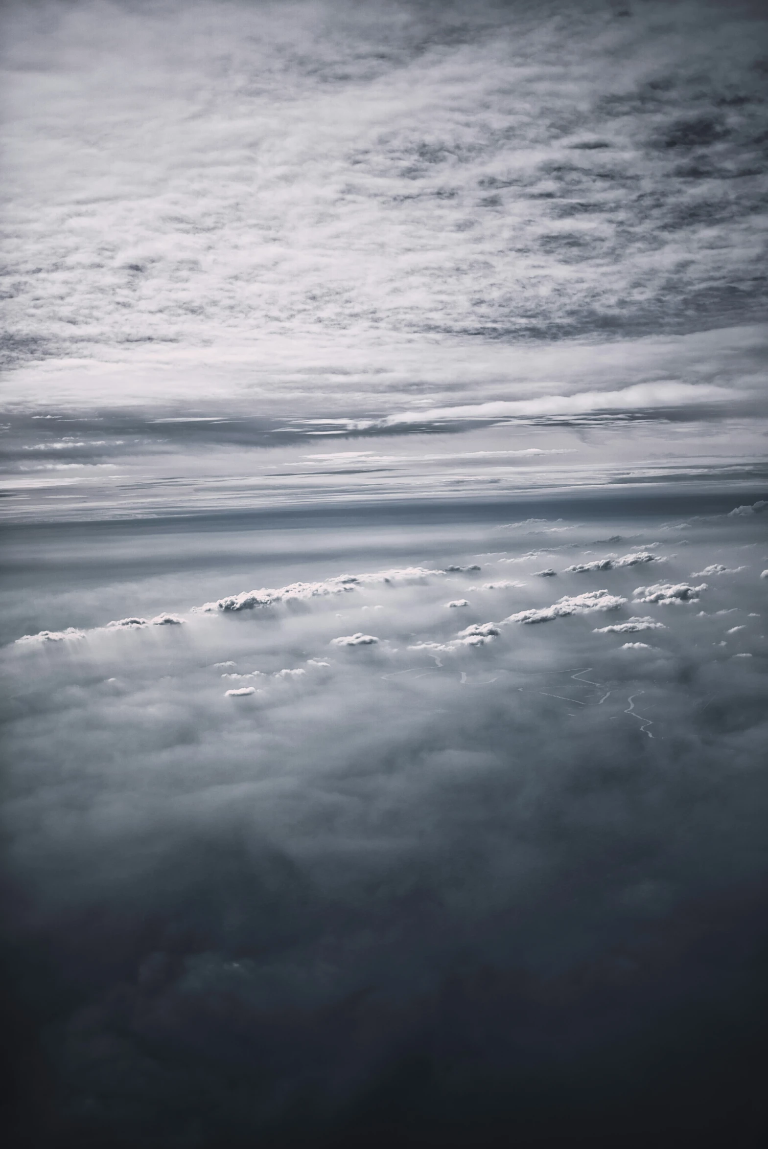 an airplane is flying in the clouds on an overcast day