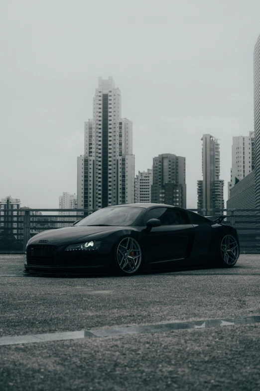 a black sports car sits parked near a city