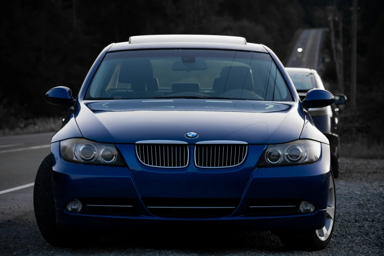 a blue car driving down the street next to another vehicle