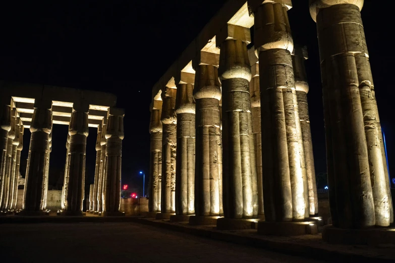 tall columns are lit up in front of a building