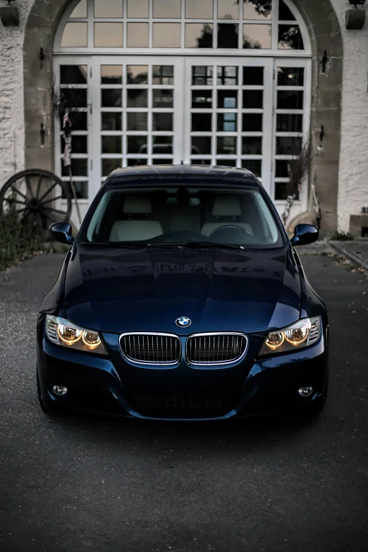 the front end of a blue car in a driveway