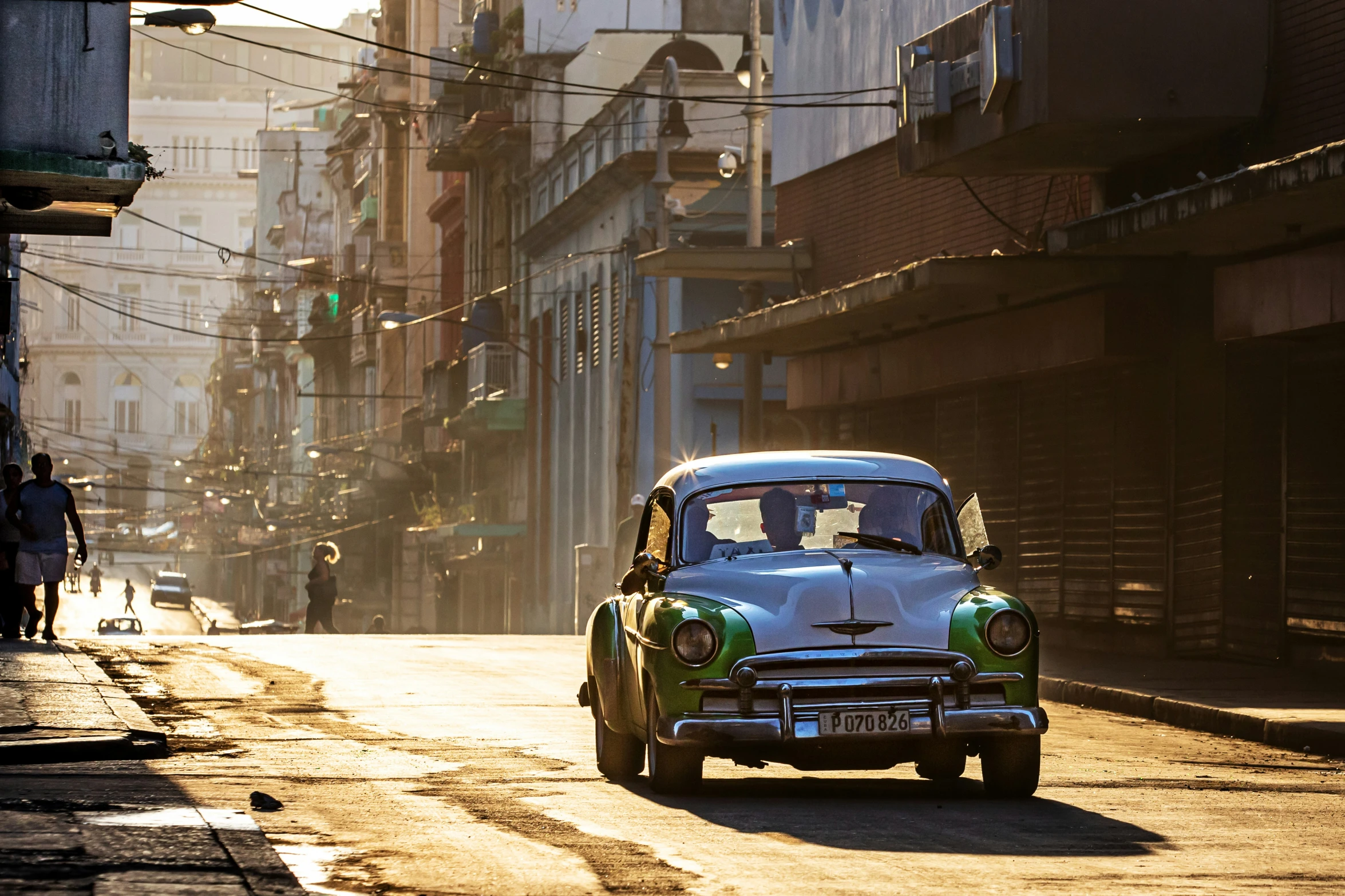 an old fashioned car traveling down a street