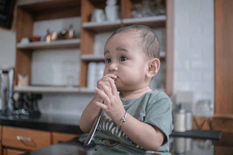 a child holds his hands together in the kitchen