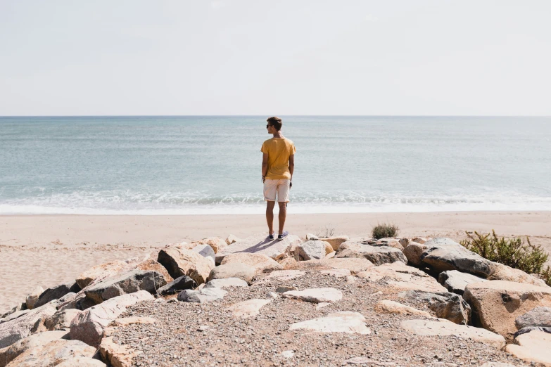 a man standing on the shore line at a beach