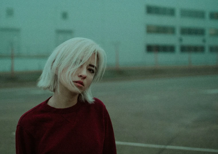 a blonde haired woman standing in the middle of the road