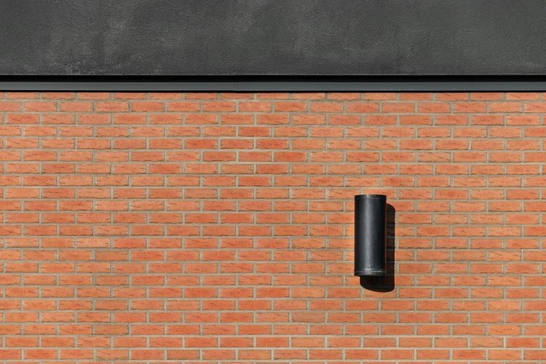 a brick wall with a black pole near by