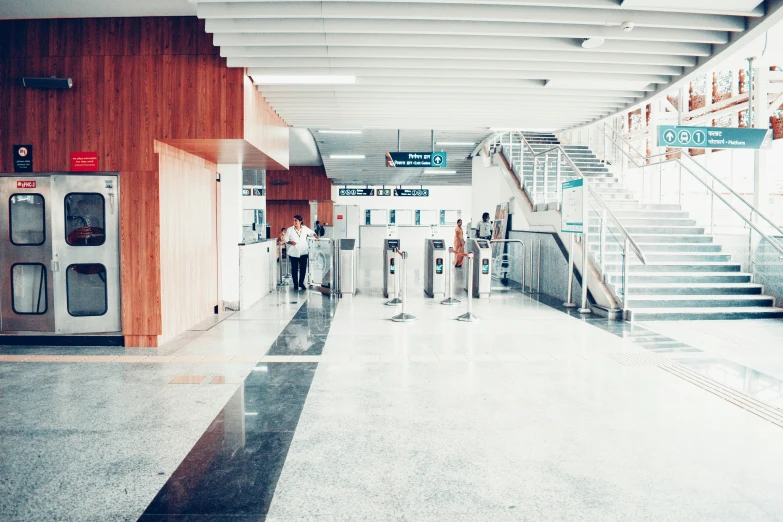 two people standing at the top of the stairs of an escalator