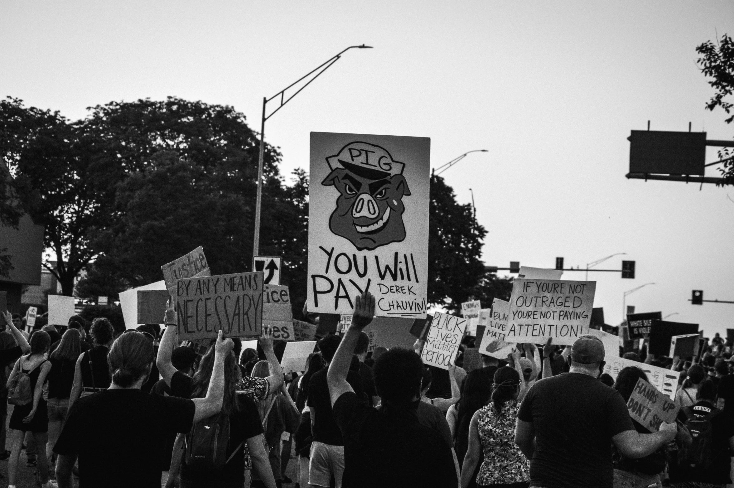 a black and white image of a group of people holding up signs