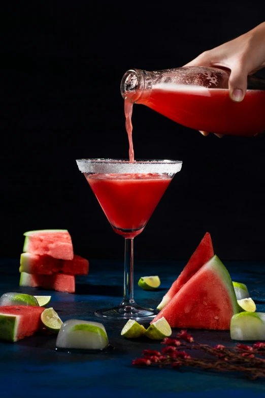 someone pours juice into the martini with sliced fruit