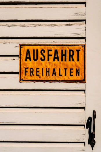 a german street sign is on the front door of a building