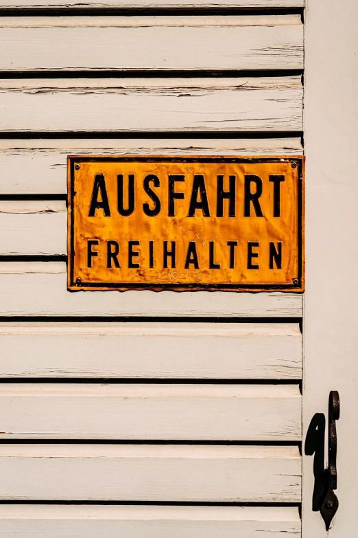 a german street sign is on the front door of a building