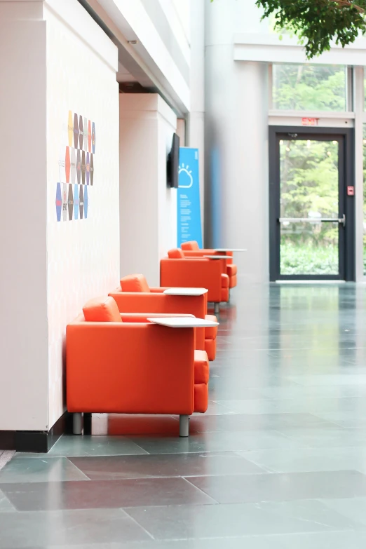 orange chairs are lined up in a large hall