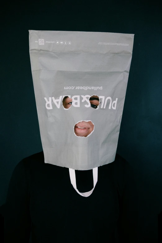 a person holding a paper bag over their face