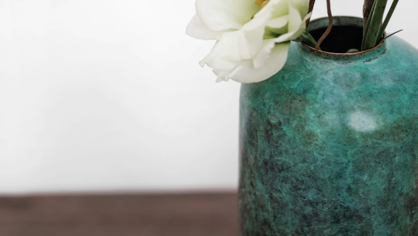 a flower in a green vase sitting on a table