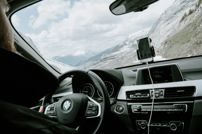 a man driving on the road with mountain in the background