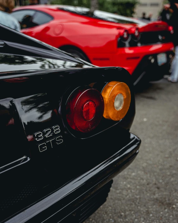 two sports cars parked in line at a car show