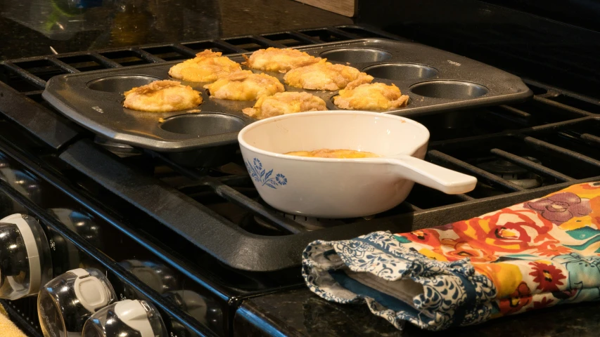 a metal pan filled with tater tots sitting on top of a stove