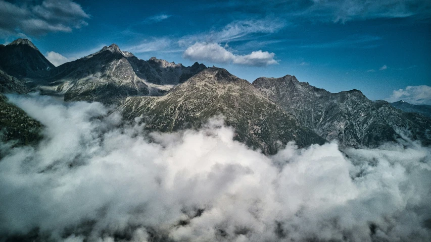 a couple of mountains with clouds floating around them