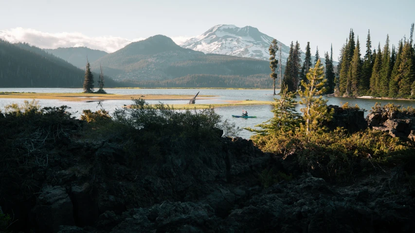 there are many trees and mountains on this lake