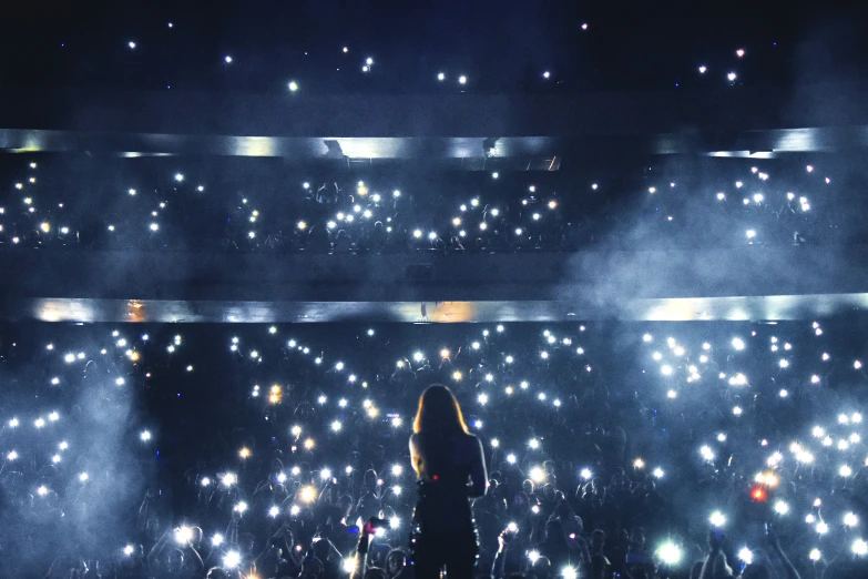 the crowd is watching a musical performance with their lights on