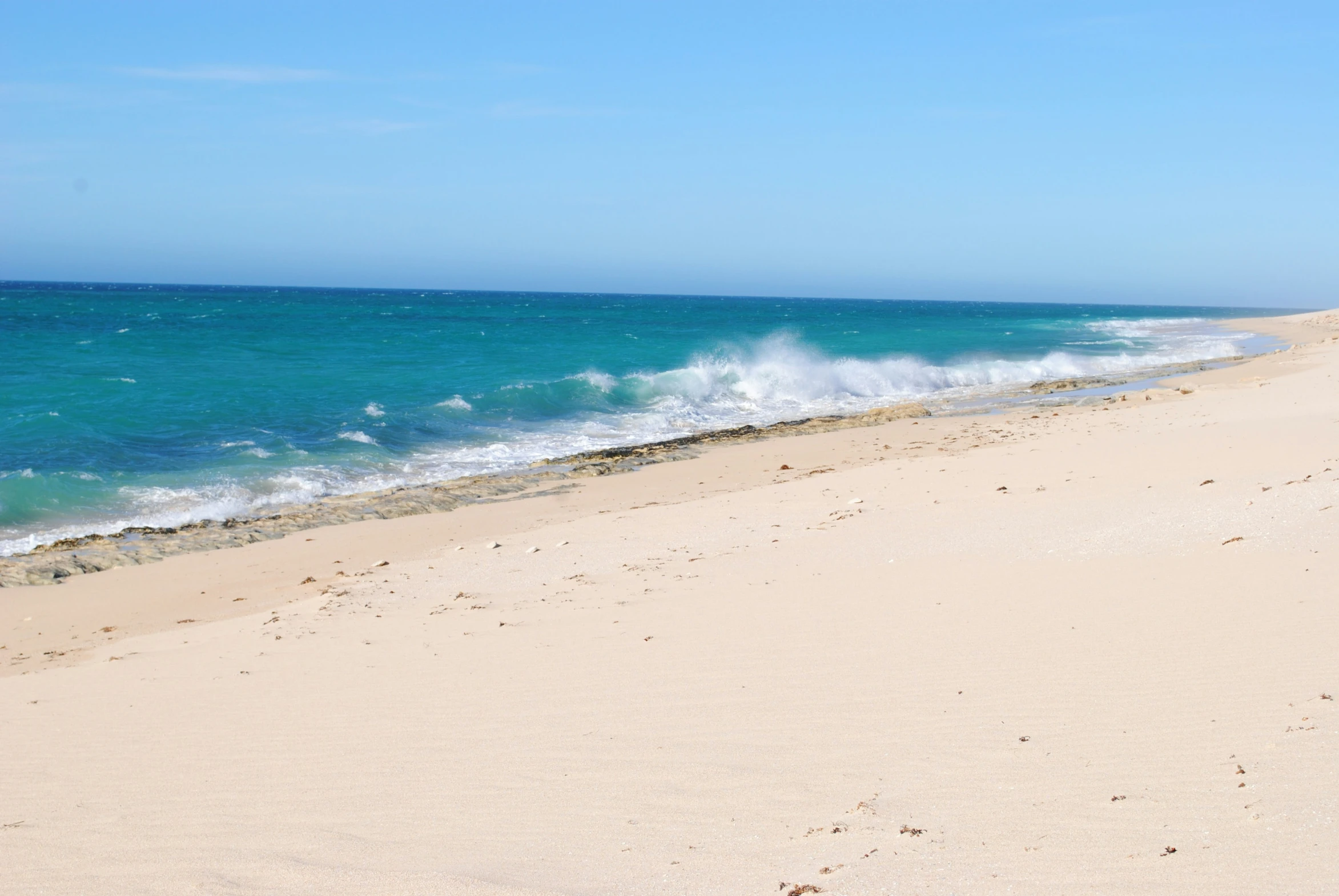 an ocean view of the beach with waves crashing into the shore