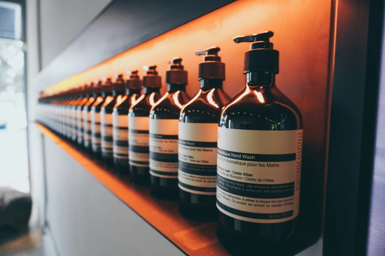 several bottle and a soap dispenser on a shelf