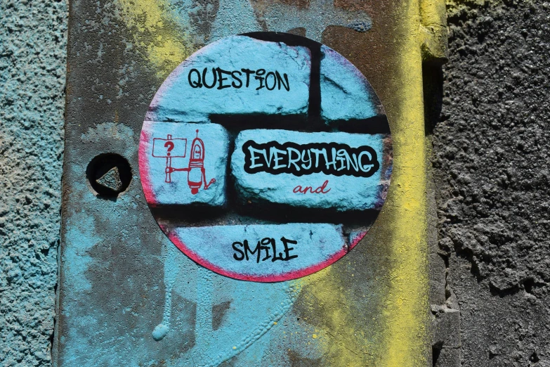 the sidewalk wall has graffiti on it with the words'question everything and smile written in black letters