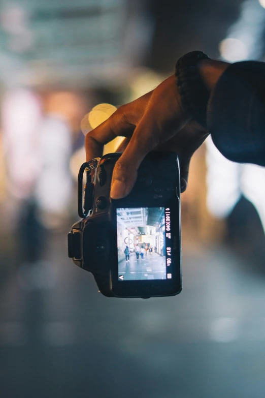 someone's hand holding out a camera with a video on it