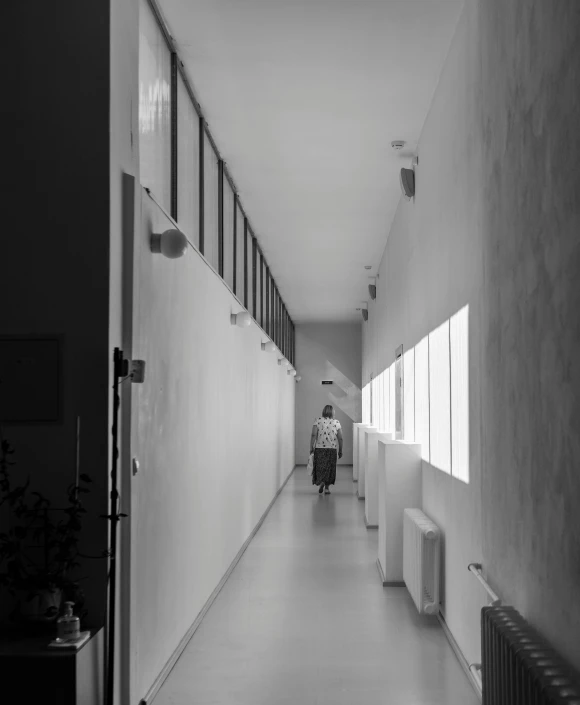 a woman is walking in the hallway of an office building