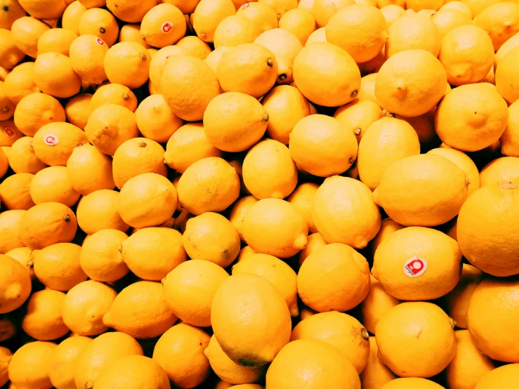 a large pile of yellow lemons next to each other