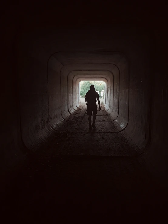 a person in a dark tunnel with a bicycle