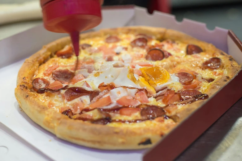 a pizza sitting on top of a box with toppings