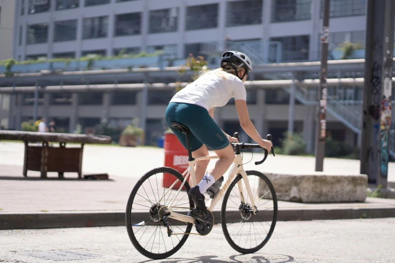 a woman riding a bike with buildings in the background