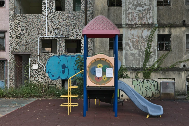 a children's playground set in front of an old building