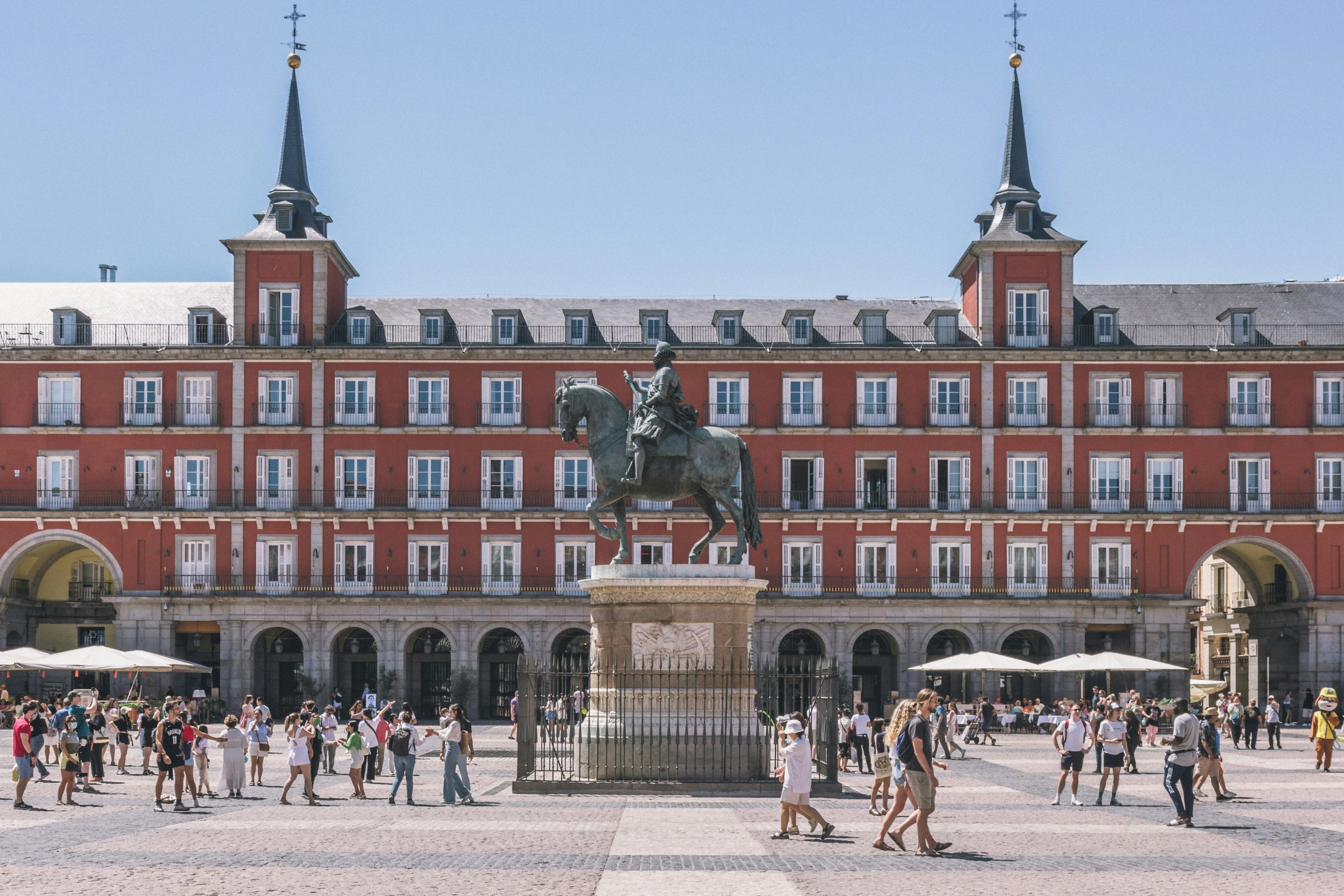 people walk around the courtyard of an historic building