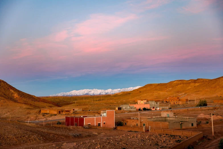 some houses in the desert with mountain in background