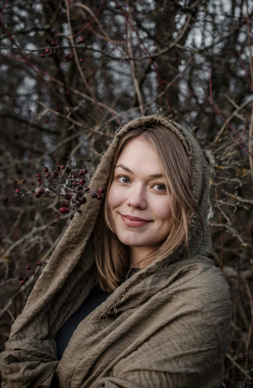 the woman is wearing a hooded coat with hood up