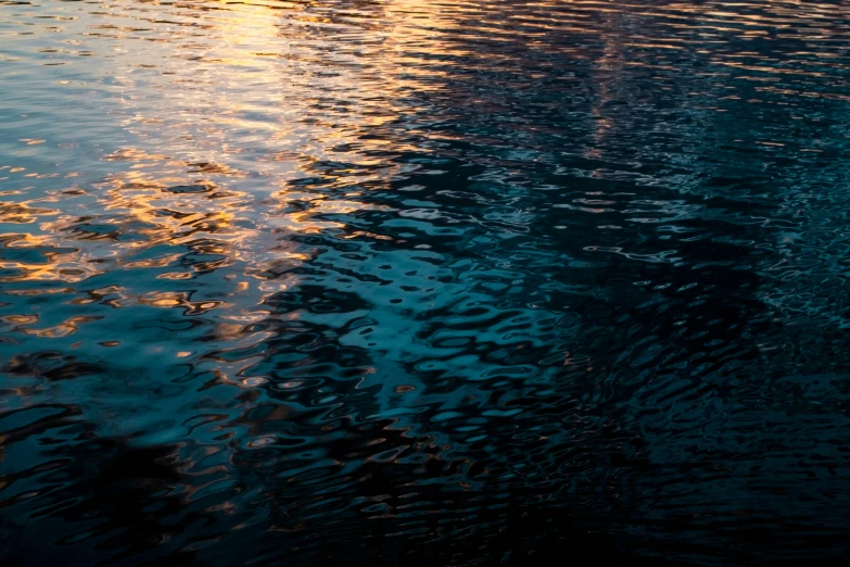 a reflection on a water surface at sunset