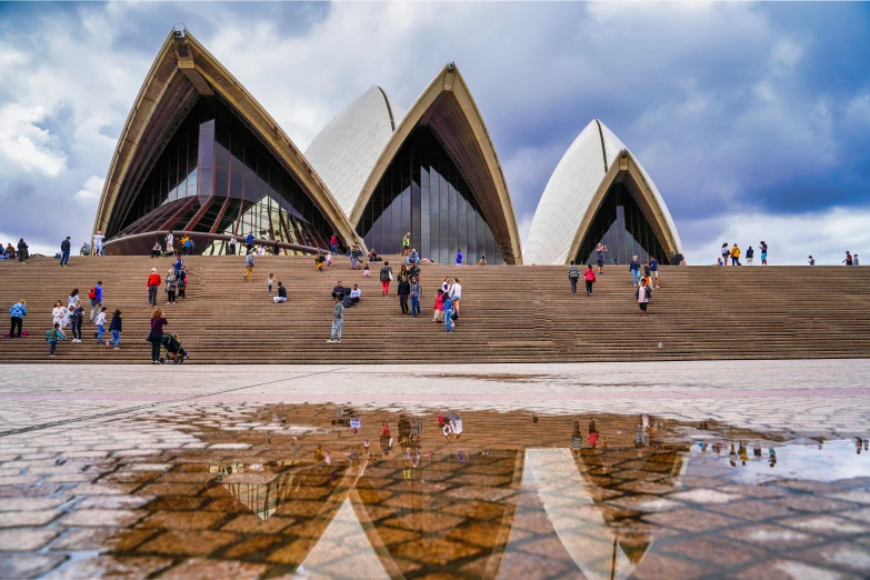 a building that looks like a opera with people walking on it