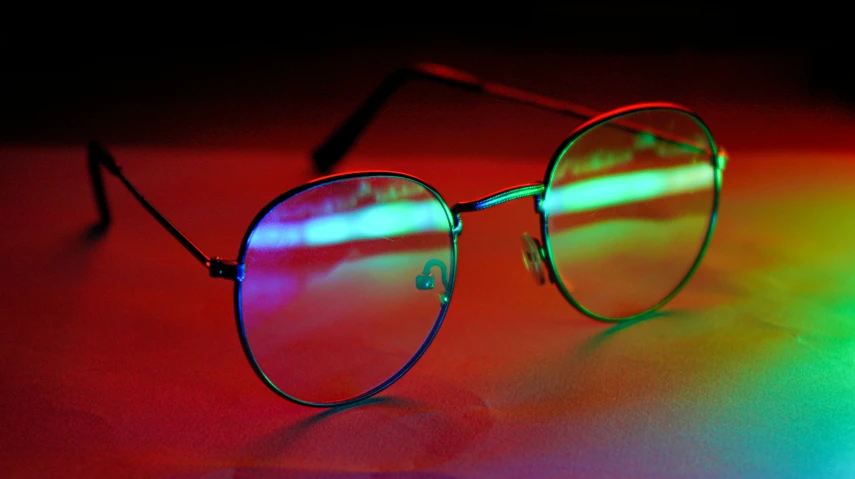 a pair of sunglasses are lit up by colored lights