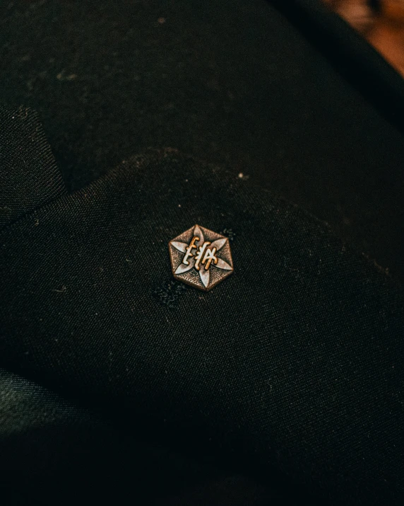 an antique diamond shaped pin is sitting on the floor