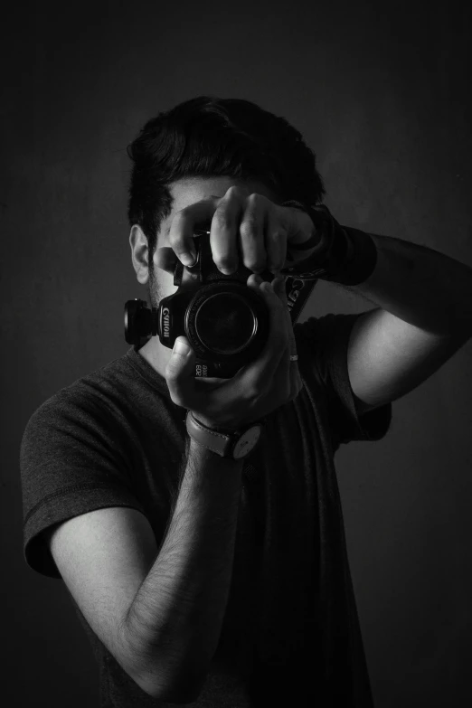 man in black shirt taking a picture with a camera