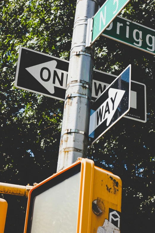 a close up of a street sign with trees in the background