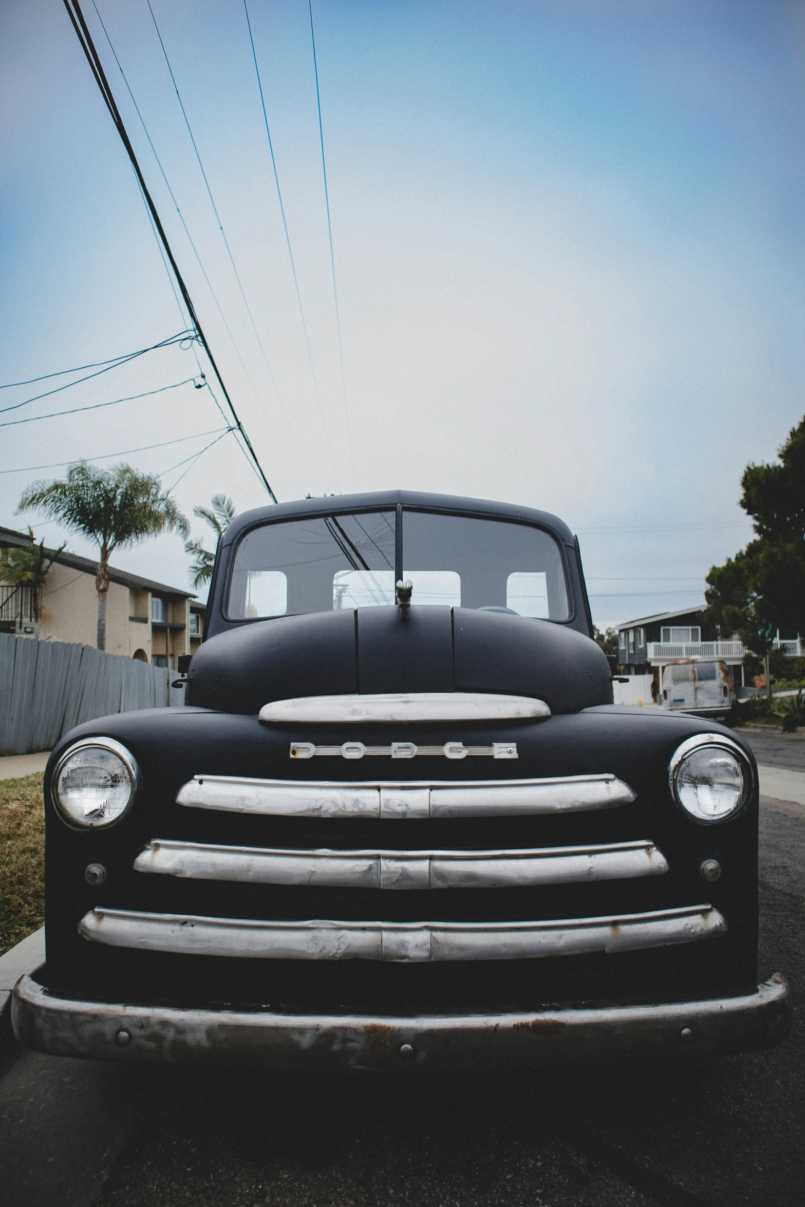 the front end of a classic black truck parked in a lot