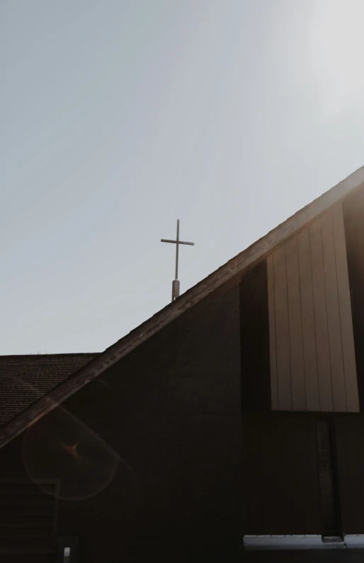 a very tall cross is sitting in the middle of a roof