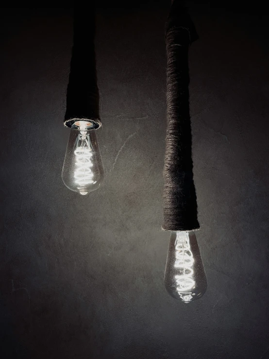 two small bulbs are lit next to a long light bulb